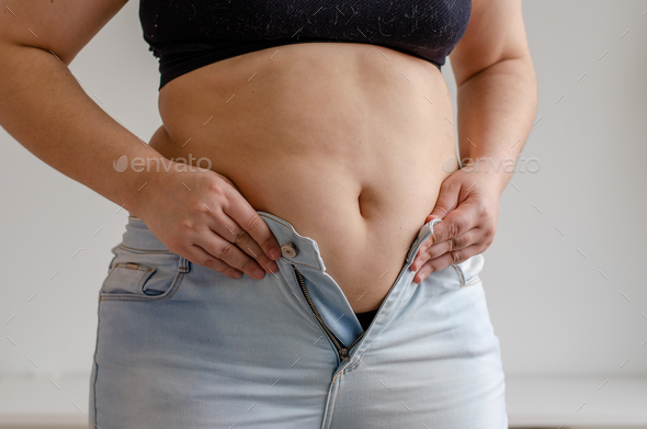 fat woman trying to zip up her jeans pants